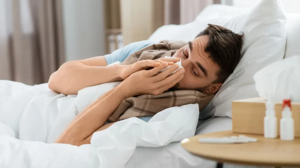 people-and-health-problem-concept-unhappy-sick-man-blowing-nose-lying-in-bed-at-home-sick-man-blowin.webp