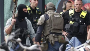 spezialeinsatzkraefte-der-polizei-bewachen-den-mutmasslichen-taeter-der-auf-einer-krankentrage-liegt.webp